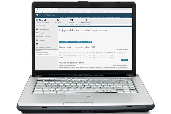  Računalnik, kjer je odprt portal eDavki in knjigovodska kartica davčnega zavezanca.